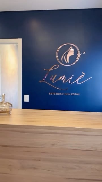 Recepção da Lumiè com o logo da marca na parede